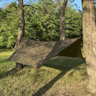 Hex tarp over hammock in forest, pitched in storm-mode with extended wings